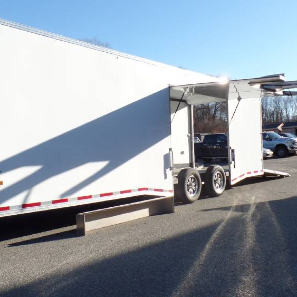 USED 2023 Pre Owned, 8.5X28 enclosed car trailer, Aluminum Frame, Escape Door with Removable Fender, Airline Track Recessed in Floor, Finished Interior, 14,000 lb. GVWR, Torsion Axles. Cabinets, Electric, Rubber Coin Floor